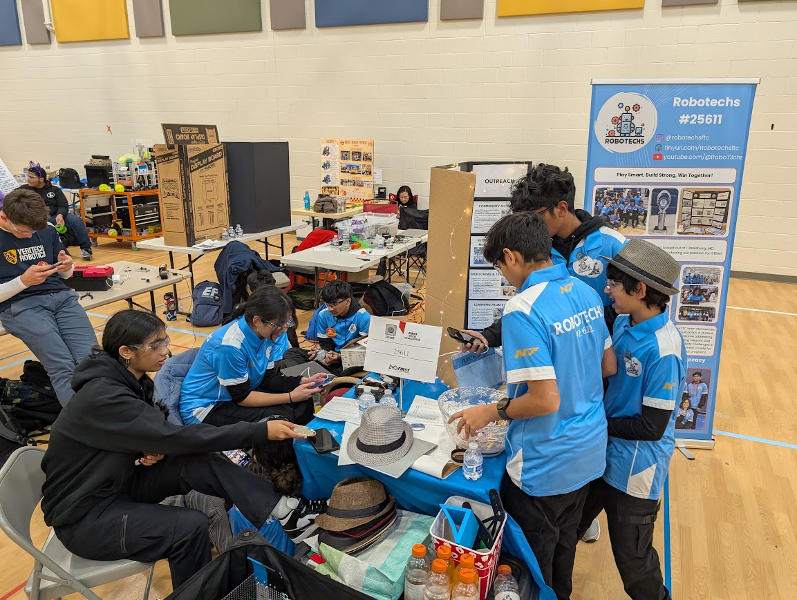 Robotechs team members working together at their competition pit table